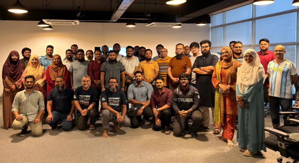 A full cohort of around thirty participants standing and kneeling together for a group photograph at the end of an Agile training session